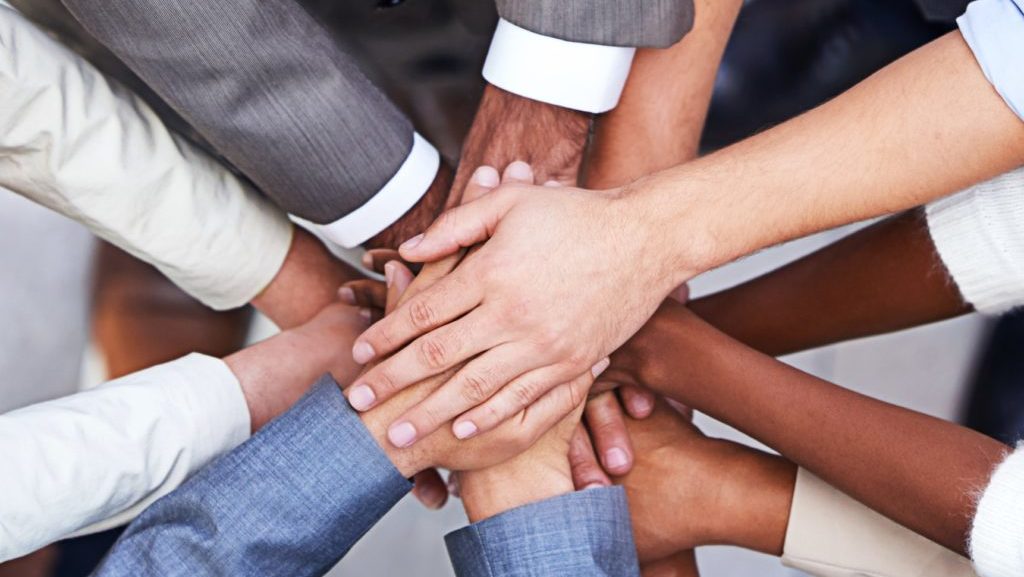 Cropped shot of a group of businesspeople standing in a huddle with their hands piled up