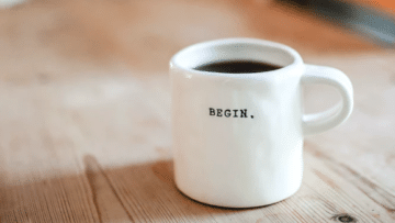A coffee cup that says the word "begin"