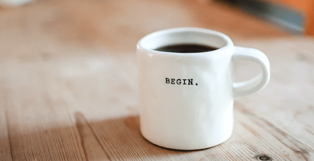 A coffee cup that says the word "begin"