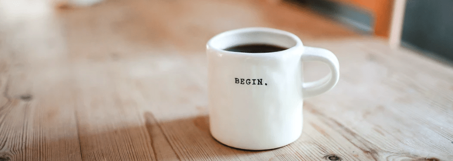 A coffee cup that says the word "begin"