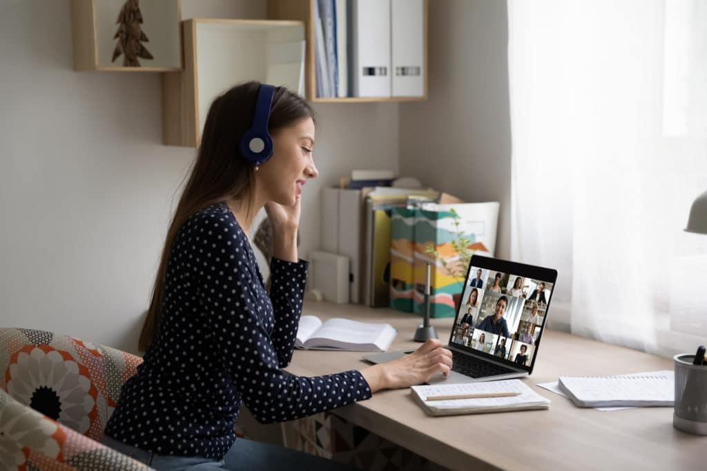 woman in headphones talk on video call with colleagues