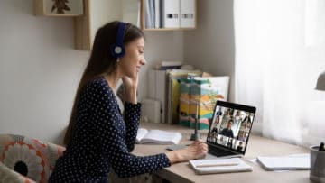 woman in headphones talk on video call with colleagues