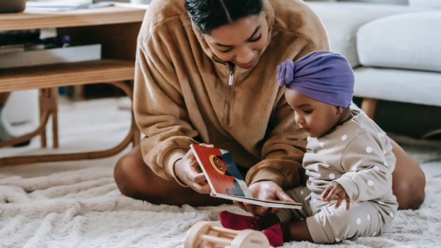 A mother reads to her infant daughter