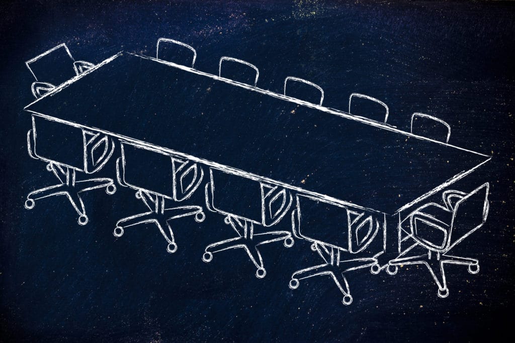 A chalk drawing on a blackboard of a board table and chairs / governance
