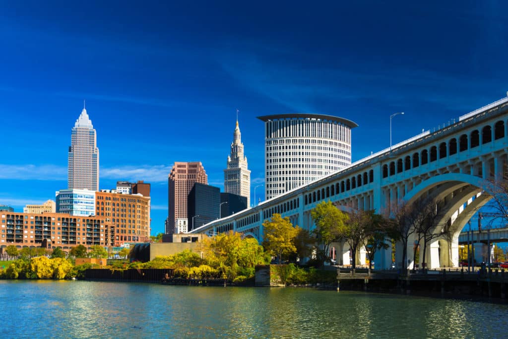 Downtown Cleveland With River, Bridge, Trees, And Deep Blue Sky
