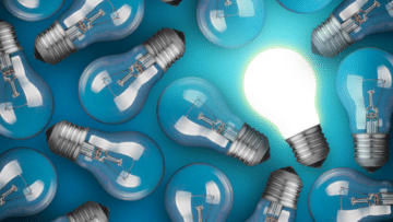 Light bulbs on blue background. One is turned on.